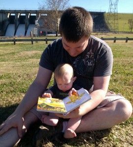 Alex reads to Grayson at park